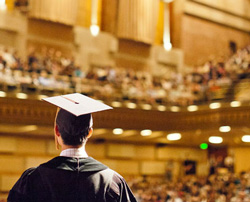 Graduate in cap and gown in an auditorium