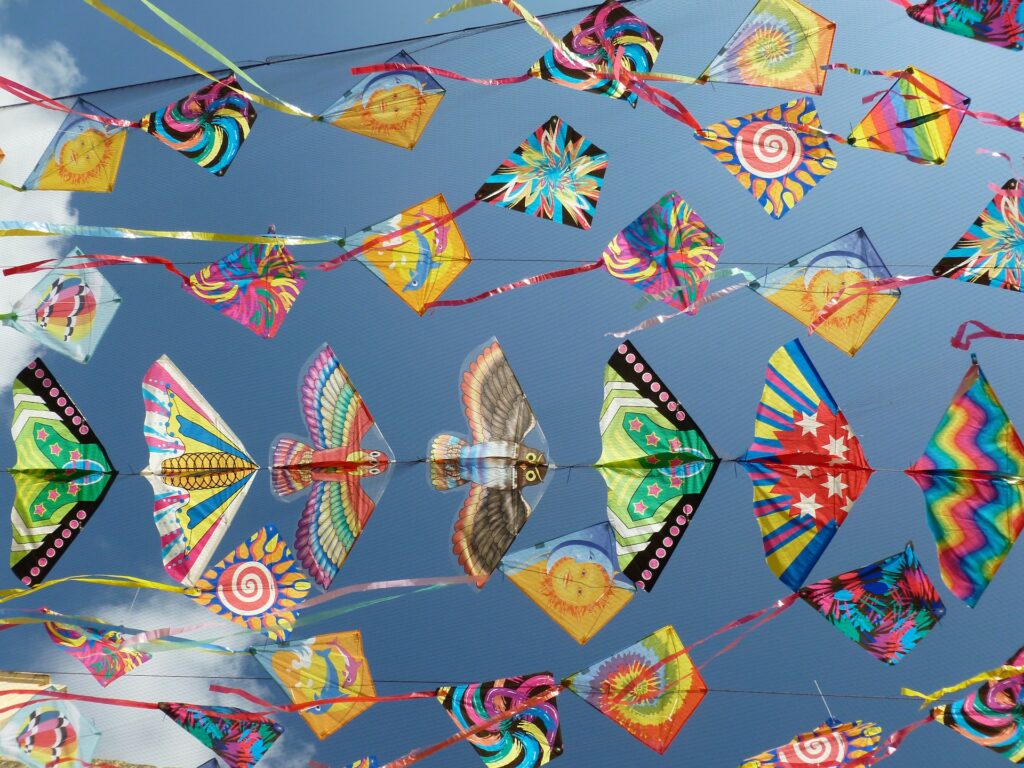 a bunch of colorful kites in the sky